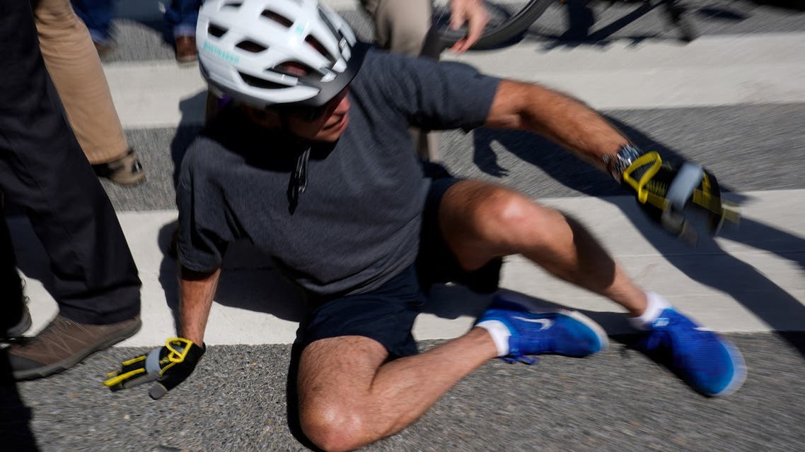 US President Joe Biden falls to the ground after riding up to members of the public during a bike ride in Rehoboth Beach, Delaware, US, June 18, 2022. (Reuters)
