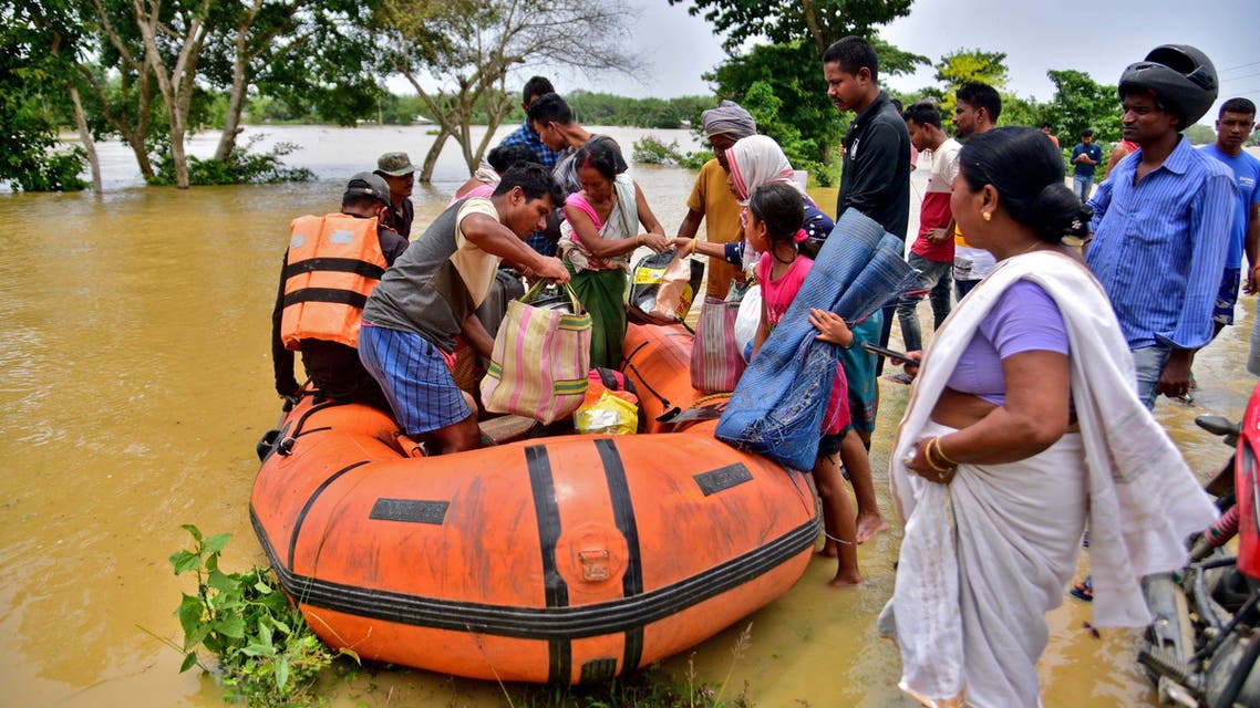 People disembark a boat after they were evacuated from a flooded village in Nagaon district, in the northeastern state of Assam, India, May 18, 2022. (Reuters)