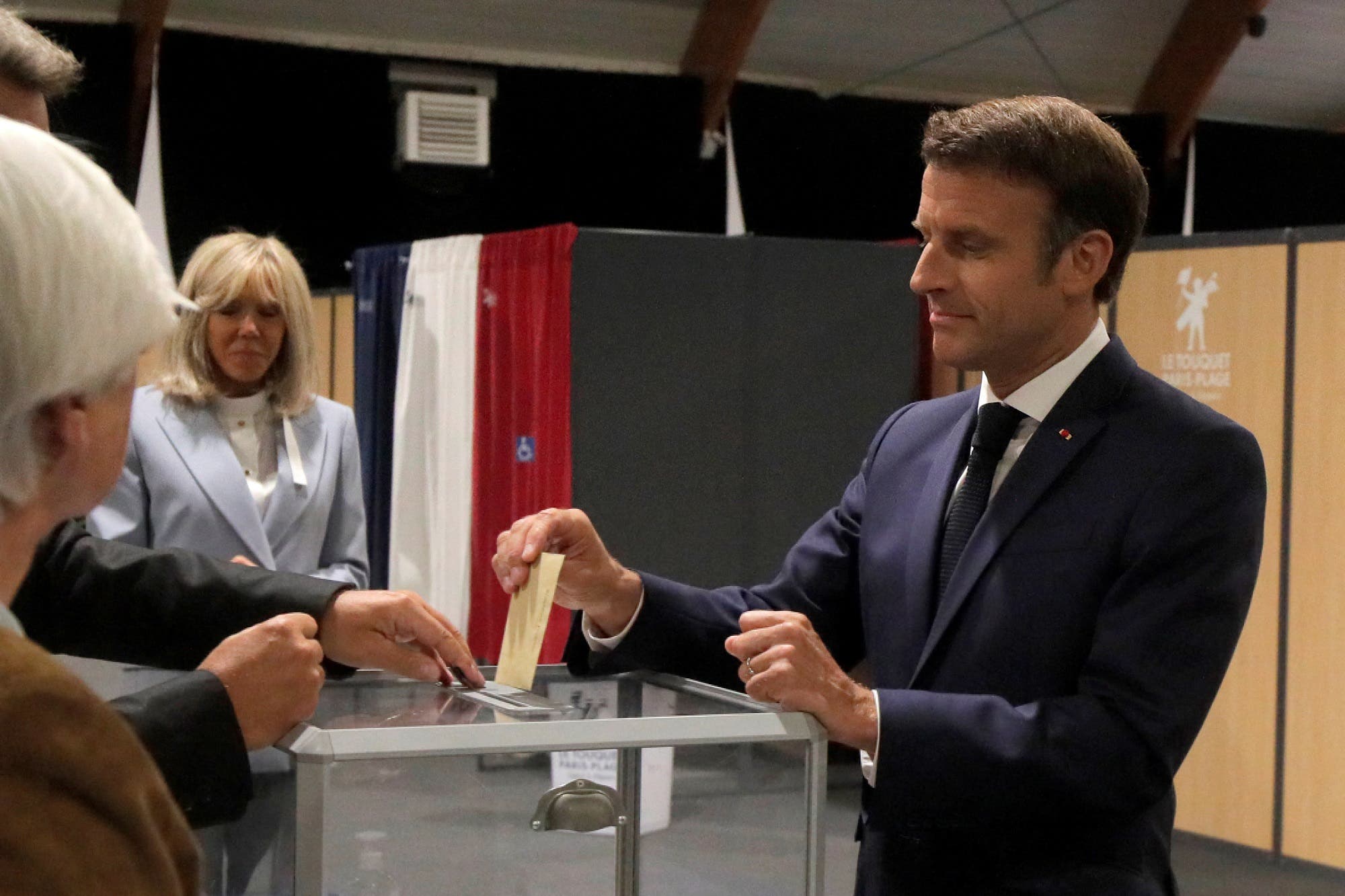 إيمانويل ماكرون يدلي بصوته خلال الجولة الأخيرة من الانتخابات البرلمانية في فرنسا في 19 يونيو (رويترز)