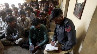 A policeman writes the details of fishermen from India, after they were detained for entering Pakistani waters, at a police station in Karachi, Pakistan. (File photo: Reuters)