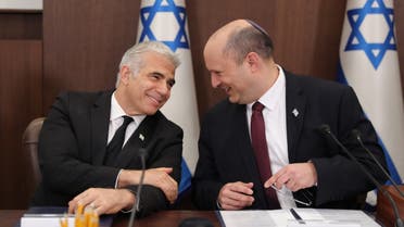 Israeli Prime Minister Naftali Bennett (R) speaks with Foreign Minister Yair Lapid (L) during a cabinet meeting at the Prime minister's office in Jerusalem, on June 19, 2022. (AFP)