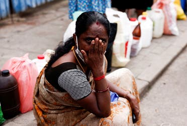 A woman waits in a queue to buy kerosene while sitting on a pavement, amid the country’s economic crisis, in Colombo, Sri Lanka, on June 17, 2022. (Reuters)