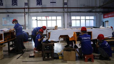 Employees work on assembling automated guided vehicles (AGV) at a Lonyu Robot Co factory in Tianjin, China. (Reuters)