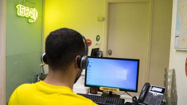 An Embrace Center volunteer takes a call from someone threatening to commit suicide. (Photo: Clement Gibon)