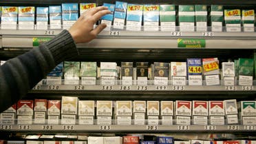 A shopkeeper reaches for a packet of cigarettes in a newsagent in London on March 5, 2008. (File photo: Reuters)