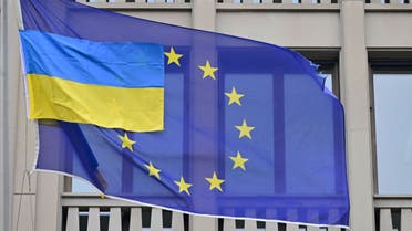 A smaller Ukrainian flag flies next to a flag of the European Union in front of the EU-representation office in Berlin on April 5, 2022. (AFP)