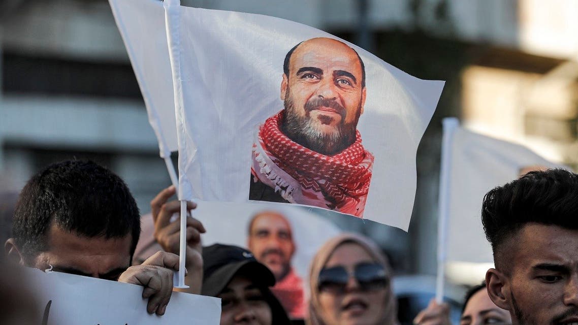 Demonstrators hold up images of late Palestinian activist Nizar Banat, who died in late June during a violent arrest by Palestinian Authority security forces, as they march during a protest in the city of Hebron in the occupied West Bank on July 13, 2021. (AFP)