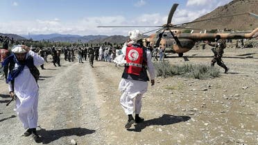 This photograph taken on June 22, 2022 and received as a courtesy of the Afghan government-run Bakhtar News Agency shows soldiers and Afghan Red Crescent Society officials near a helicopter at an earthquake hit area in Afghanistan's Gayan district, Paktika province. (AFP)