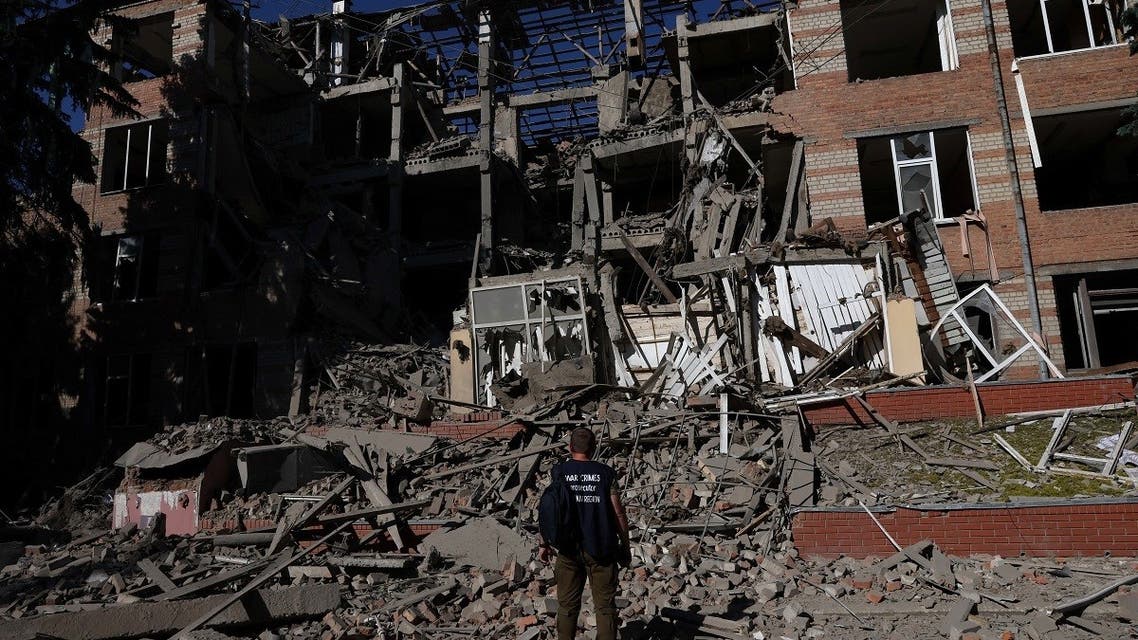 A worker from the war crimes prosecutor's office takes in the damage from overnight shelling that landed on a building of Kharkiv's Housing and Communal College as Russia's attack on Ukraine continues in Kharkiv, Ukraine, June 21, 2022. (Reuters)