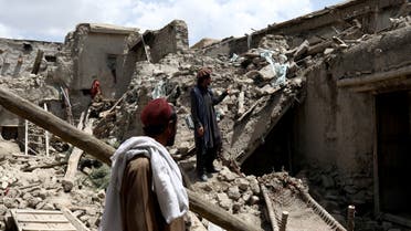 Afghan men stand on the debris of a house that was destroyed by an earthquake in Gayan, Afghanistan, June 23, 2022. (Reuters)