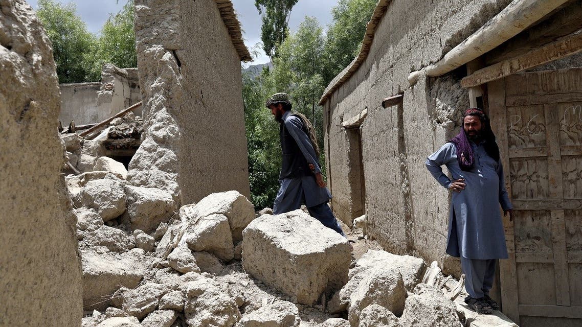 Afghan men stand on the debris of their house that was damaged by an earthquake in Gayan, Afghanistan, on June 23, 2022. (Reuters)