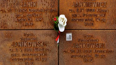 A portrait and flowers are attached to a wall with the names of killed Polish officers during a commemoration ceremony at a memorial complex in Katyn, some 350 kilometers (217 miles) west of Moscow, on April 10, 2012. (Reuters)