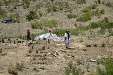 In this picture taken on June 24, 2022, an Afghan man stands near a cemetery where more than 10 members of a family were buried together who were killed after an earthquake in Gayan district, Paktika province. (AFP)