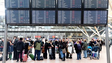 File photo of passengers queueing behind a display showing canceled flights during a strike at the airport Fuhlsbuettel in Hamburg. (Reuters)
