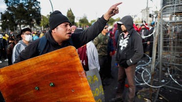 A demonstrator with a makeshift shield gestures behind a barricade as protests continue amid a stalemate between the government of President Guillermo Lasso and largely indigenous demonstrators who demand an end to emergency measures, in Quito, Ecuador, on June 26, 2022. (Reuters)