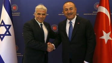 Turkish Foreign Minister Mevlut Cavusoglu (R) shakes hands with Israeli Foreign Minister Yair Lapid (L) ahead of a meeting in Ankara on June 23, 2022. (AFP)