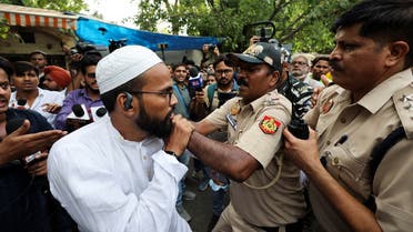 Police officials try to detain a supporter of All India Students' Association (AISA) during a protest against what they say attacks on Muslims following clashes last week triggered by remarks made by ruling Bharatiya Janata Party (BJP) figures on Prophet Mohammad, at Jantar Mantar, in New Delhi, India, on June 13, 2022. (Reuters)