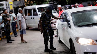 A Sri Lanka Air Force member checks the tokens of people queueing for fuel due to fuel shortage, amid the country's economic crisis, in Colombo, Sri Lanka, June 27, 2022. (Reuters)