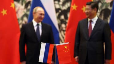The Russian and Chinese national flags are seen on the table as Russia's President Vladimir Putin (back L) and his China's President Xi Jinping (back R) stand during a signing ceremony at the Diaoyutai State Guesthouse in Beijing on November 9, 2014. (File photo: AFP)
