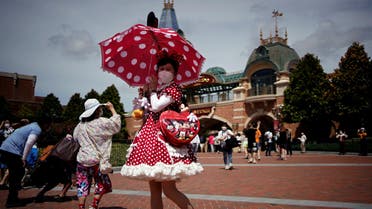 A visitor wearing a face mask poses at the Shanghai Disney Resort, as the Shanghai Disneyland theme park reopens after being shut for the coronavirus disease (COVID-19) outbreak, in Shanghai, China June 30, 2022. (Reuters)