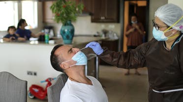 A worker of a company, which is offering testing for the coronavirus disease (COVID-19) and check-in for travellers at their homes, wears a protective mask as she takes a swab sample of Nicholas Couvaras, as Dubai resumes flights, in Dubai, United Arab Emirates July 13, 2020. (File photo: Reuters)