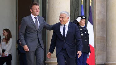 French President Emmanuel Macron welcomes Israeli Prime Minister Yair Lapid as he arrives for a meeting at the Elysee Palace in Paris, France, July 5, 2022. (Reuters)
