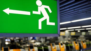 An emergency exit sign is seen next to counters at the airport in Frankfurt, Germany. (File photo: Reuters)
