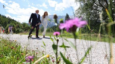 British Prime Minister Boris Johnson (L) and his wife Carrie Johnson walk after a welcoming ceremony at Elmau Castle, southern Germany on June 26, 2022 prior to the start of the G7 Summit. (AFP)