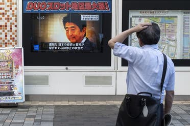 A man looks at a television broadcast showing news about the attack on former Japanese Prime Minister Shinzo Abe earlier in the day, along a street of Tokyo on July 8, 2022. (AFP)
