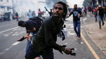 A demonstrator throws back a tear gas grenade toward police members as police use tear gas and water cannons to disperse demonstrators near President’s residence during a protest demanding the resignation of President Gotabaya Rajapaksa, amid the country’s economic crisis, in Colombo, Sri Lanka, on July 8, 2022. (Reuters)