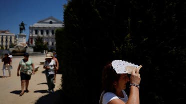 A tourist shelters from the sun with a fan during the second heatwave of the year in Madrid, Spain, on July 10, 2022. (Reuters)