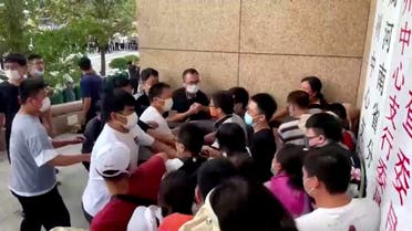 Plain-clothed security personnel scuffle with demonstrators during a protest over the freezing of deposits by some rural-based banks, outside a People's Bank of China building in Zhengzhou, Henan province, China July 10, 2022, in this screengrab from video obtained by Reuters. (Reuters)