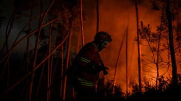 A firefighter works to extinguish a wildfire at Casais do Vento in Alvaiazere on July 10, 2022.  (AFP)