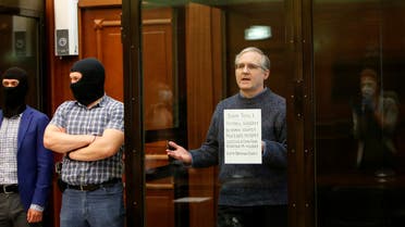 Former US Marine Paul Whelan, who was detained and accused of espionage, holds a sign as he stands inside a defendants' cage during his verdict hearing in Moscow, Russia June 15, 2020. (Reuters)