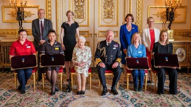 Britain’s Queen Elizabeth II (5L) and Britain’s Prince Charles, Prince of Wales (5R) pose with a number of officials and executives from NHS at Windsor Castle, west of London on July 12, 2022. (Pool/AFP)