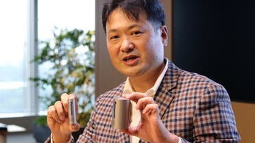Kazuo Tadanobu, CEO of Panasonic's Energy Company holds a prototype of the 4680 format battery cell (R) next to the current 2170 battery supplied to Tesla Inc during a news conference in Tokyo, Japan, on October 25, 2021. (Reuters)