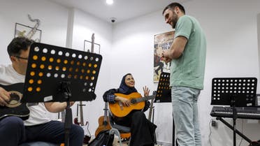 Wejdan Hajji, a 28-year-old employee at a firm selling medical supplies, attends a guitar class at the Yamaha Music Centre in Saudia Arabia's capital Riyadh on June 11, 2022. (AFP)