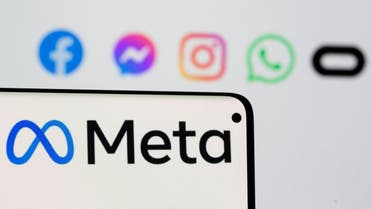 Facebook's new rebrand logo Meta is seen on smartpone in front of displayed logo of Facebook, Messenger, Intagram, Whatsapp and Oculus. (Reuters)