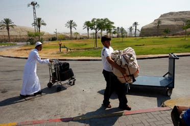 مسافرون يحملون أمتعتهم بعد خروجهم من معبر ألنبي  (أرشيفية) 