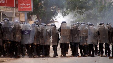 Riot policemen march with shields in formation to confront anti-coup protesters during clashes amdist mass demonstrations against military rule in the centre of Sudan's capital Khartoum on June 30, 2022. At least nine Sudanese demonstrators were killed on June 30 as security forces sought to quash mass rallies of protesters demanding an end to military rule, pro-democracy medics said. In one of the most violent days this year in an ongoing crackdown on the anti-coup movement, AFP correspondents reported security forces firing tear gas and stun grenades to disperse tens of thousands of protesters. (AFP)