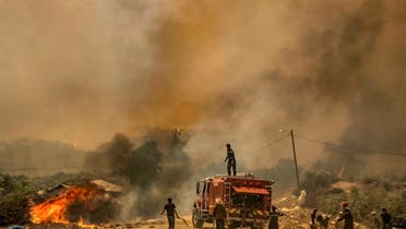 Firefighters battle a blaze raging in Morocco's northern region of Ksar Sghir on July 14, 2022 . (AFP)