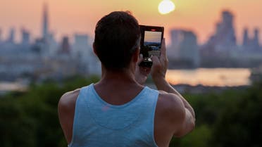 People take pictures of the sunset from Greenwich Park view point, during a heatwave in London, Britain, July 18, 2022. (File photo: Reuters)