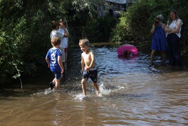 أطفال يلهون في بحيرة في بريطانيا بحثاً عن الانتعاش بظل موجة الحر