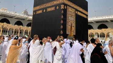 Muslim pilgrims circumambulate the Kaaba, the cubic building at the Grand Mosque, as they left social distancing during the minor pilgrimage, known as Umrah, in the Muslim holy city of Mecca, Saudi Arabia, Sunday, March 6, 2022. (AP)