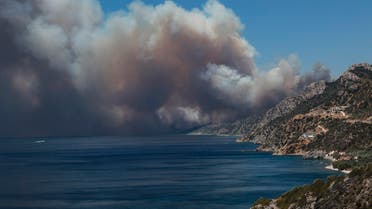 The smoke of a wildfire billows as it approaches Vatera coastal resort on the eastern island of Lesbos on July 23, 2022. Residents were evacuated as the wildfire threatened properties. (AFP)
