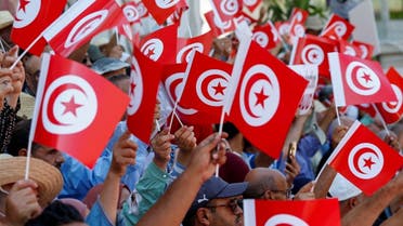 A file photo shows Tunisian protesters waving flags of the country, July 23, 2022. (Reuters)