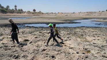 People cross the Diyala River, a tributary of the Tigris, where decreasing water levels this year have raised alarm among residents, near Baghdad, Iraq, on June 29, 2022. (AP)