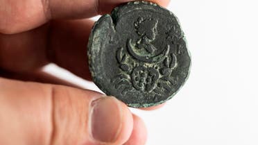 This picture taken at the office of Israel's Antiquities Authority in Jerusalem on July 26, 2022 shows a 1850-year-old rare coin depicting the moon goddess recently recovered from the sea off the Carmel coast in the northern city of Haifa. (AFP)
