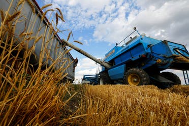 Una cosechadora carga un camión con grano mientras cosecha trigo durante el conflicto Ucrania-Rusia en la aldea de Muzykivka, controlada por Rusia, en la región de Kherson, Ucrania, 26 de julio de 2022. REUTERS/Alexander Ermochenko