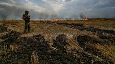 FILE PHOTO: A Ukrainian serviceman stands on a burning wheat field near a frontline on a border between Zaporizhzhia and Donetsk regions, as Russia’s attack on Ukraine continues, Ukraine July 17, 2022. REUTERS/Dmytro Smolienko/File Photo